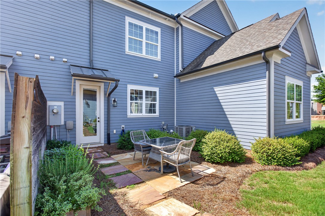 112 Tuttle Street Clemson, SC 29631 - Photo 2 of 46 A quaint patio area, perfectly sized for intimate outdoor gatherings, is set against the home's striking blue siding.