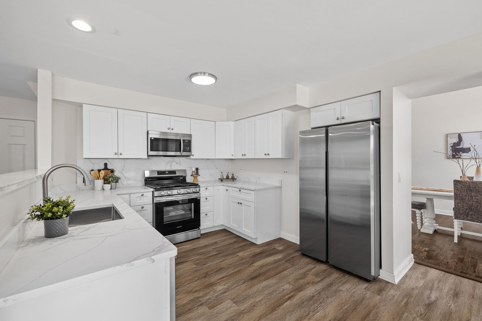 147 Willow Bend Bolingbrook, IL 60490 - Photo 6 of 22 a kitchen with stainless steel appliances granite countertop a refrigerator a stove a sink dishwasher and a refrigerator with wooden floor