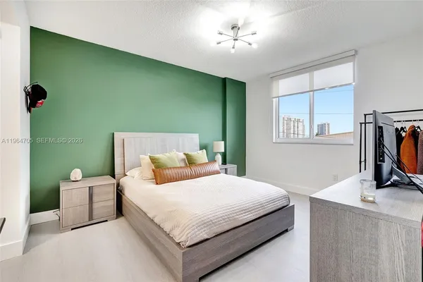 a bedroom with a bed wooden floor and a window