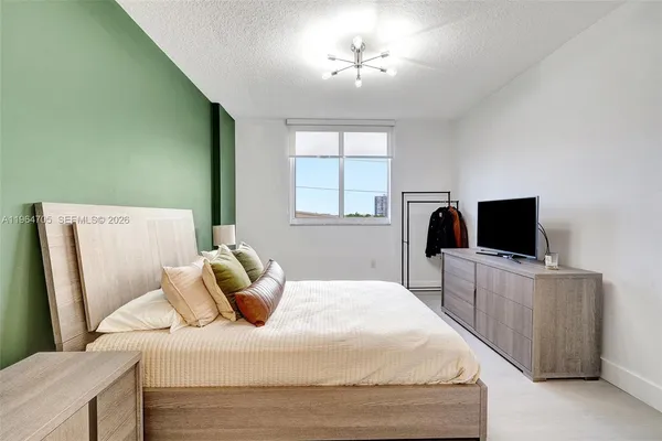 a bedroom with a bed and flat screen tv