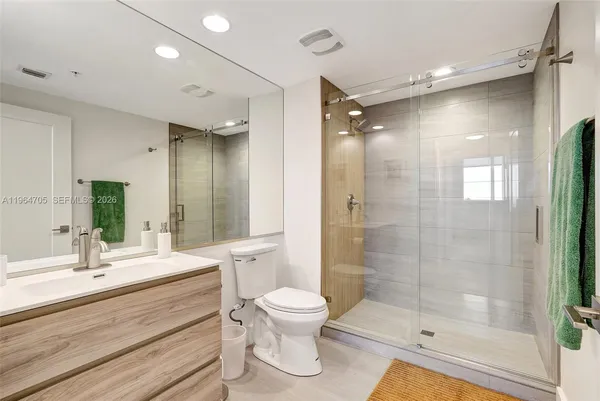 a bathroom with a double vanity sink toilet and shower