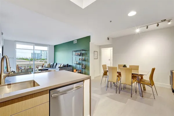 a kitchen with sink a counter and chairs