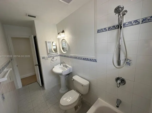 a white toilet sitting next to a bathroom sink