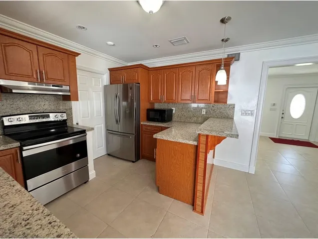 a kitchen with stainless steel appliances granite countertop a refrigerator stove and sink