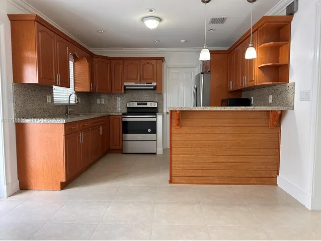 a kitchen with stainless steel appliances granite countertop a stove top oven a sink and dishwasher