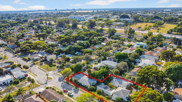 a aerial view of a house with swimming pool and large trees