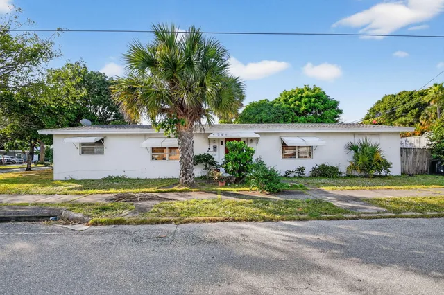 a view of a house with a yard and potted plants