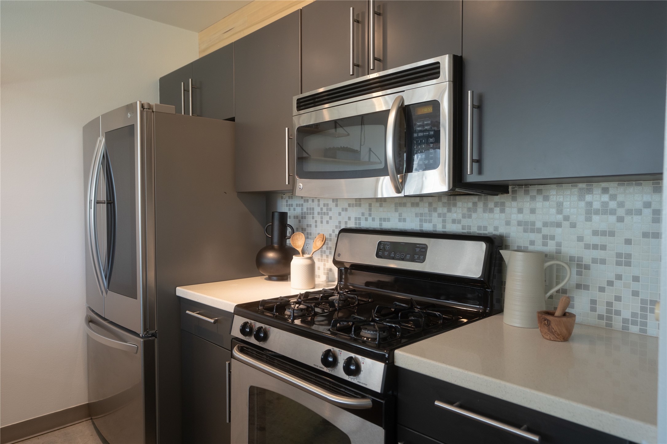 4801 South Congress Avenue, Unit H5 Austin, TX 78745 - Photo 14 of 39 Kitchen with stainless steel appliances, light countertops, tasteful backsplash, and dark cabinets