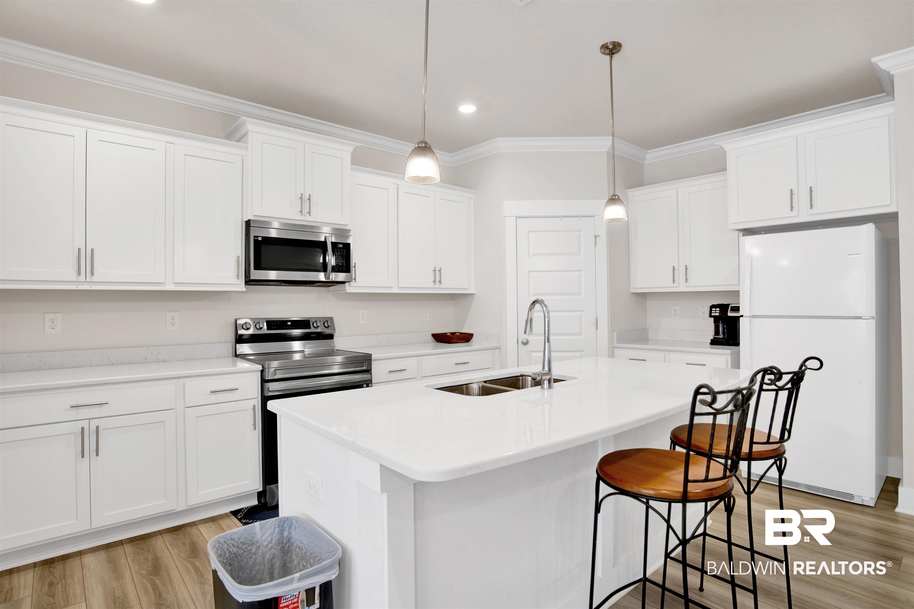 1174 Pheasant Circle Foley, AL 36535 - Photo 12 of 29 Kitchen featuring stainless steel appliances, crown molding, white cabinets, a breakfast bar, and an island with sink