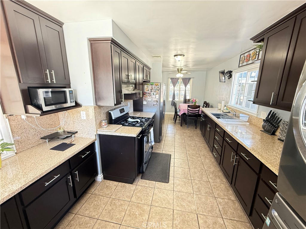 10430 McVine Avenue Sunland, CA 91040 - Photo 28 of 52 a kitchen with stainless steel appliances a sink stove top oven and cabinets