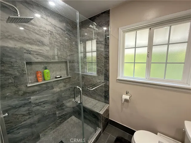a bathroom with a double vanity sink toilet and shower