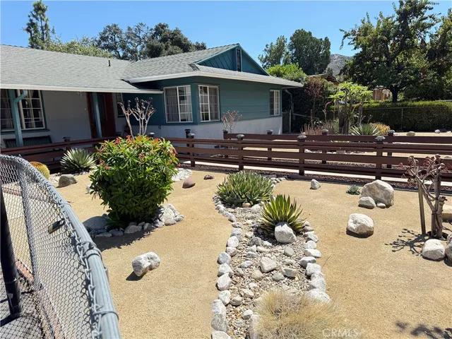 a view of a house with backyard and sitting area