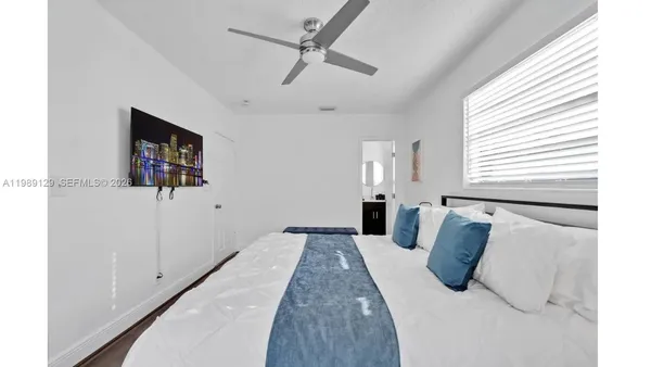 a bedroom with a bed and a flat screen tv