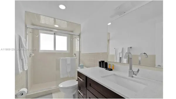 a bathroom with a sink a toilet and shower