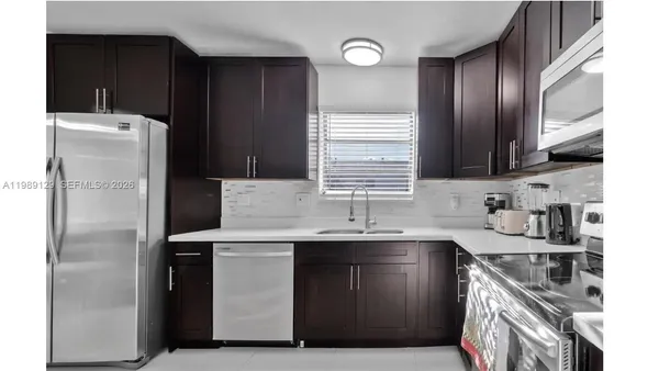 a kitchen with stainless steel appliances a sink stove and refrigerator