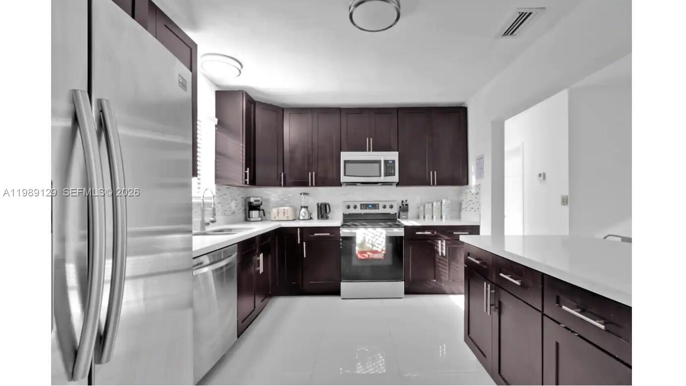 3161 Riverland Road Fort Lauderdale, FL 33312 - Photo 22 of 25 a large kitchen with cabinets and stainless steel appliances