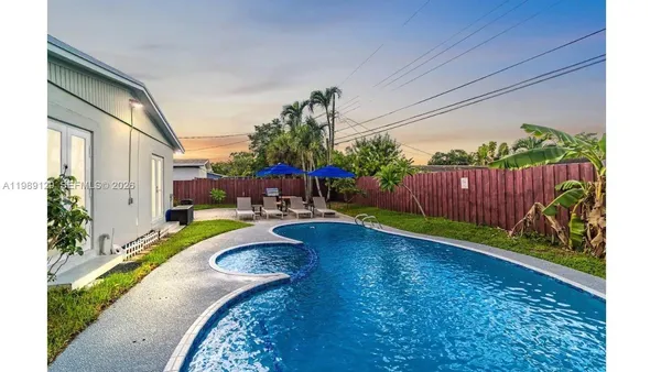 a view of swimming pool with garden and patio