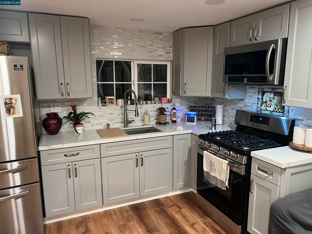a kitchen with white cabinets stainless steel appliances and a sink