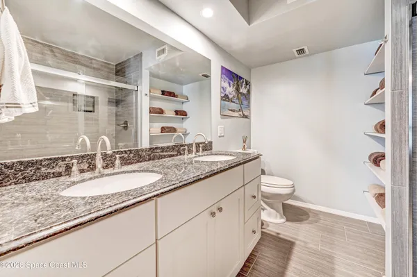 a bathroom with a granite countertop sink toilet and shower