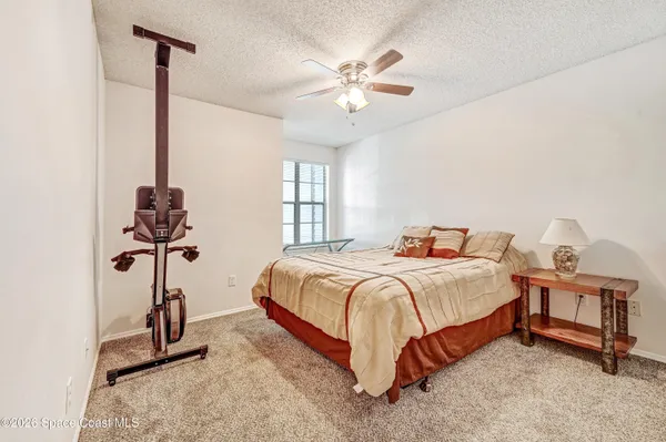 a bedroom with a bed a chandelier and a window