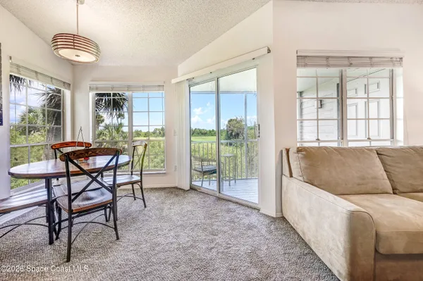 a living room with furniture and a floor to ceiling window