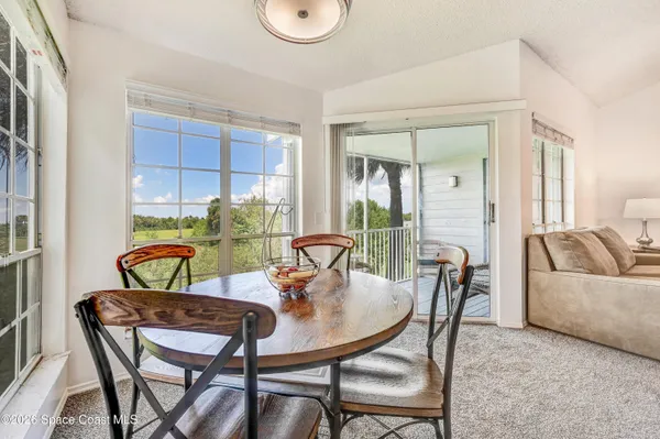 a view of a dining room with furniture and a potted plant
