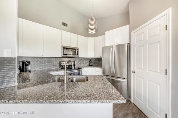 a kitchen with stainless steel appliances granite countertop a sink refrigerator and microwave