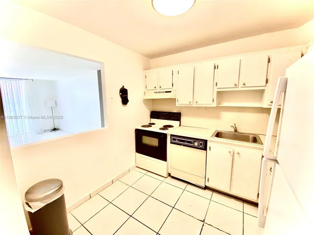 a kitchen with stainless steel appliances a stove a sink and white cabinets