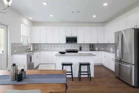 a kitchen with a refrigerator and a stove top oven