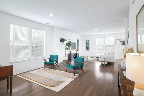 a living room with furniture a flat screen tv and a window