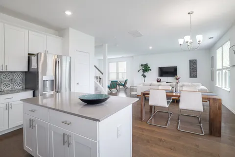 a kitchen with granite countertop white cabinets and a stove