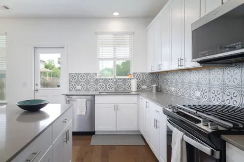 a kitchen with stainless steel appliances granite countertop a refrigerator a stove a sink and a microwave