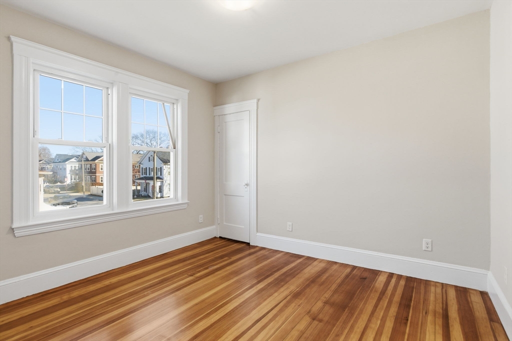 113 Minot Street, Unit 2 Boston, MA 02122 - Photo 20 of 34 a view of an empty room with wooden floor and a window