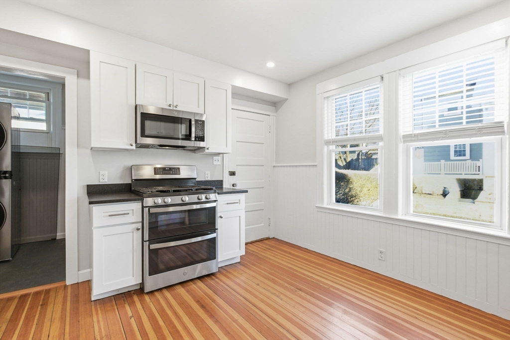 113 Minot Street, Unit 2 Boston, MA 02122 - Photo 2 of 34 a kitchen with stainless steel appliances a stove a sink and a microwave