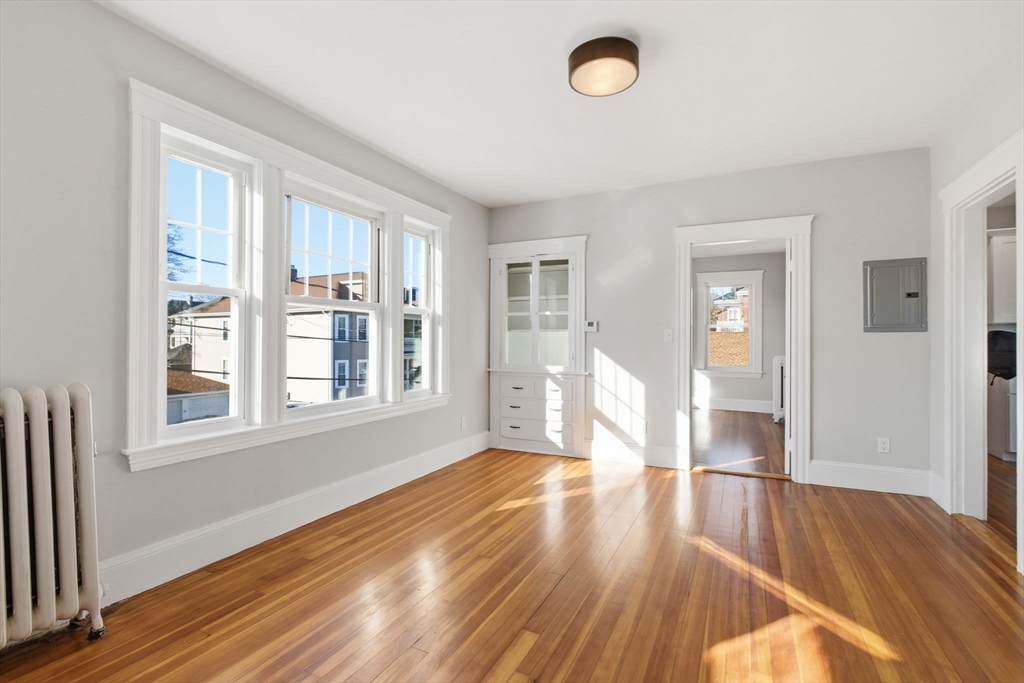 113 Minot Street, Unit 2 Boston, MA 02122 - Photo 32 of 34 an empty room with wooden floor and windows
