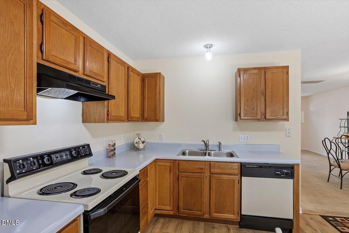 5503 Fieldcross Court Raleigh, NC 27610 - Photo 15 of 26 a kitchen with stainless steel appliances a stove a sink cabinets and a wooden floor