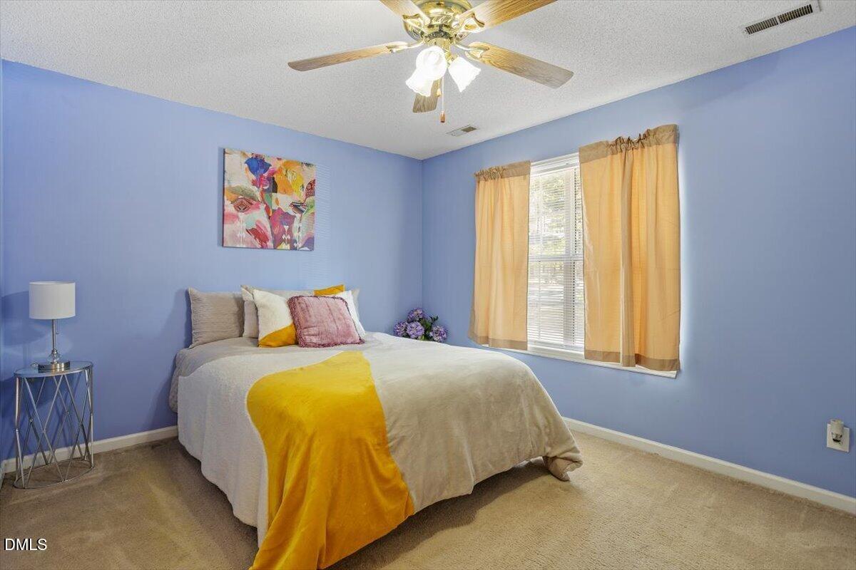5503 Fieldcross Court Raleigh, NC 27610 - Photo 18 of 26 a spacious bedroom with a bed and a window