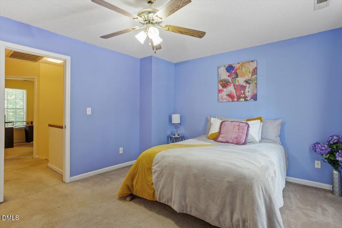 5503 Fieldcross Court Raleigh, NC 27610 - Photo 19 of 26 a bedroom with a bed and a chandelier
