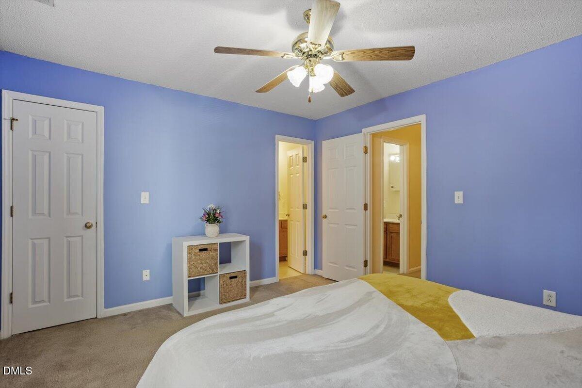 5503 Fieldcross Court Raleigh, NC 27610 - Photo 20 of 26 a bedroom with a bed and a chandelier