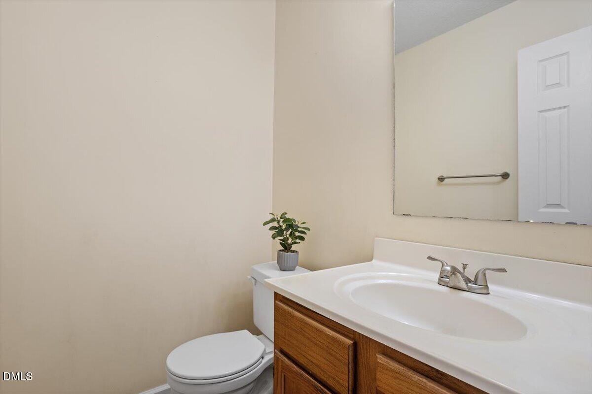 5503 Fieldcross Court Raleigh, NC 27610 - Photo 21 of 26 a bathroom with a sink a toilet and mirror
