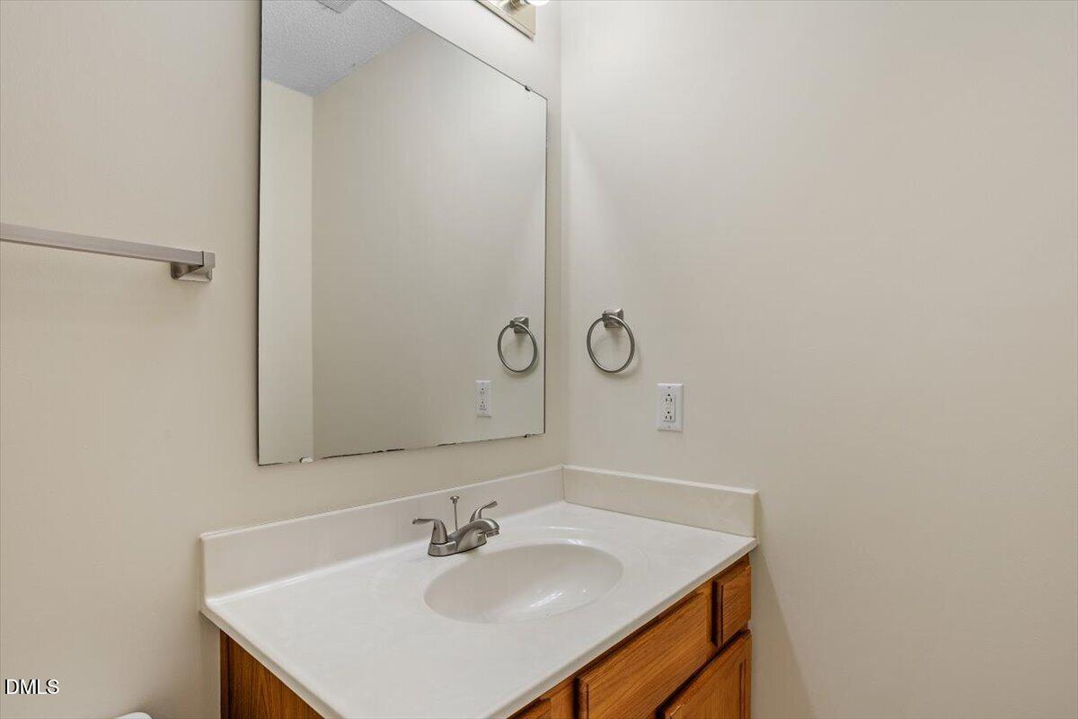 5503 Fieldcross Court Raleigh, NC 27610 - Photo 22 of 26 a bathroom with a sink and a mirror