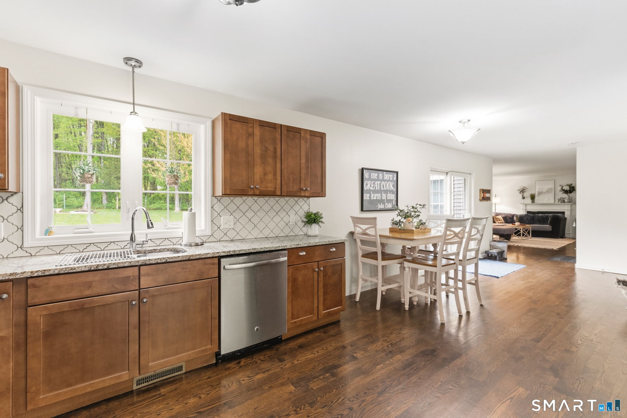 160 Canal Road Suffield, CT 06078 - Photo 10 of 40 a open kitchen with stainless steel appliances granite countertop a stove top oven a sink a dining table and chairs with wooden floor