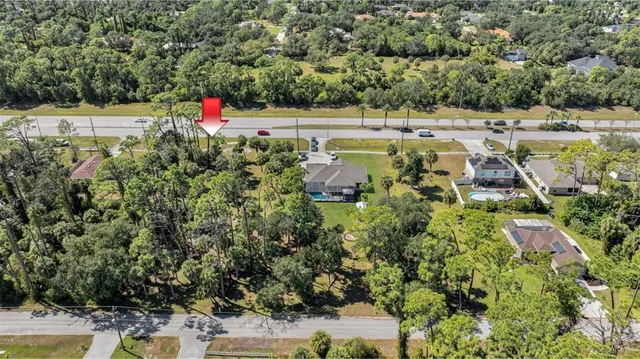 an aerial view of residential house with outdoor space and trees around