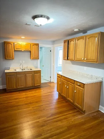 a kitchen with stainless steel appliances granite countertop a sink and a wooden floors