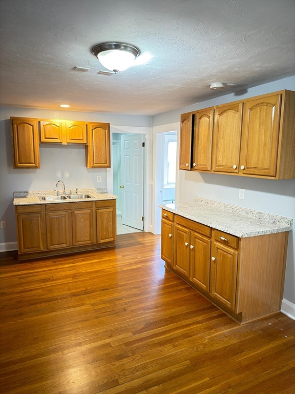 917 Main Street, Unit 2 Southbridge, MA 01550 - Photo 3 of 7 a kitchen with stainless steel appliances granite countertop a sink and a wooden floors