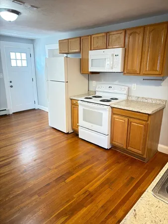 a kitchen with granite countertop a stove a sink and a refrigerator