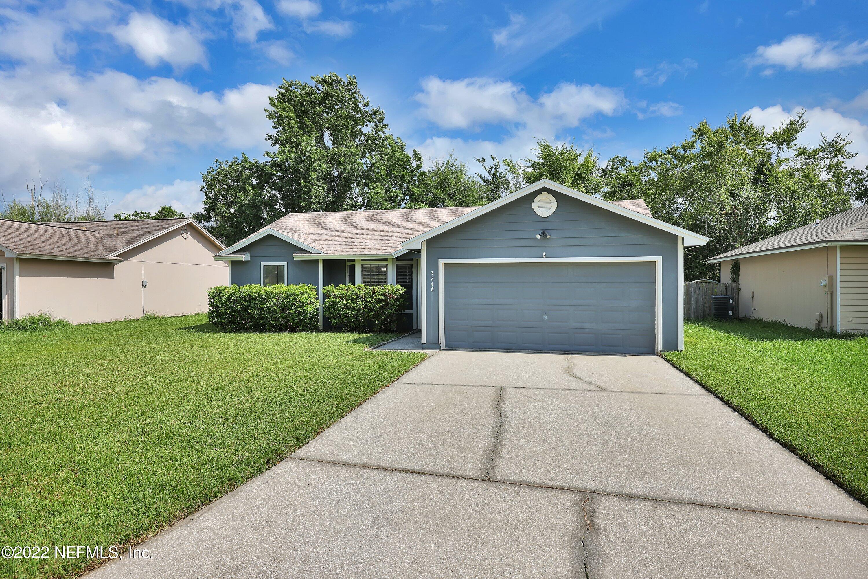 3248 Dowitcher Lane Orange Park, FL 32065 - Photo 2 of 26 a front view of a house with a yard and garage