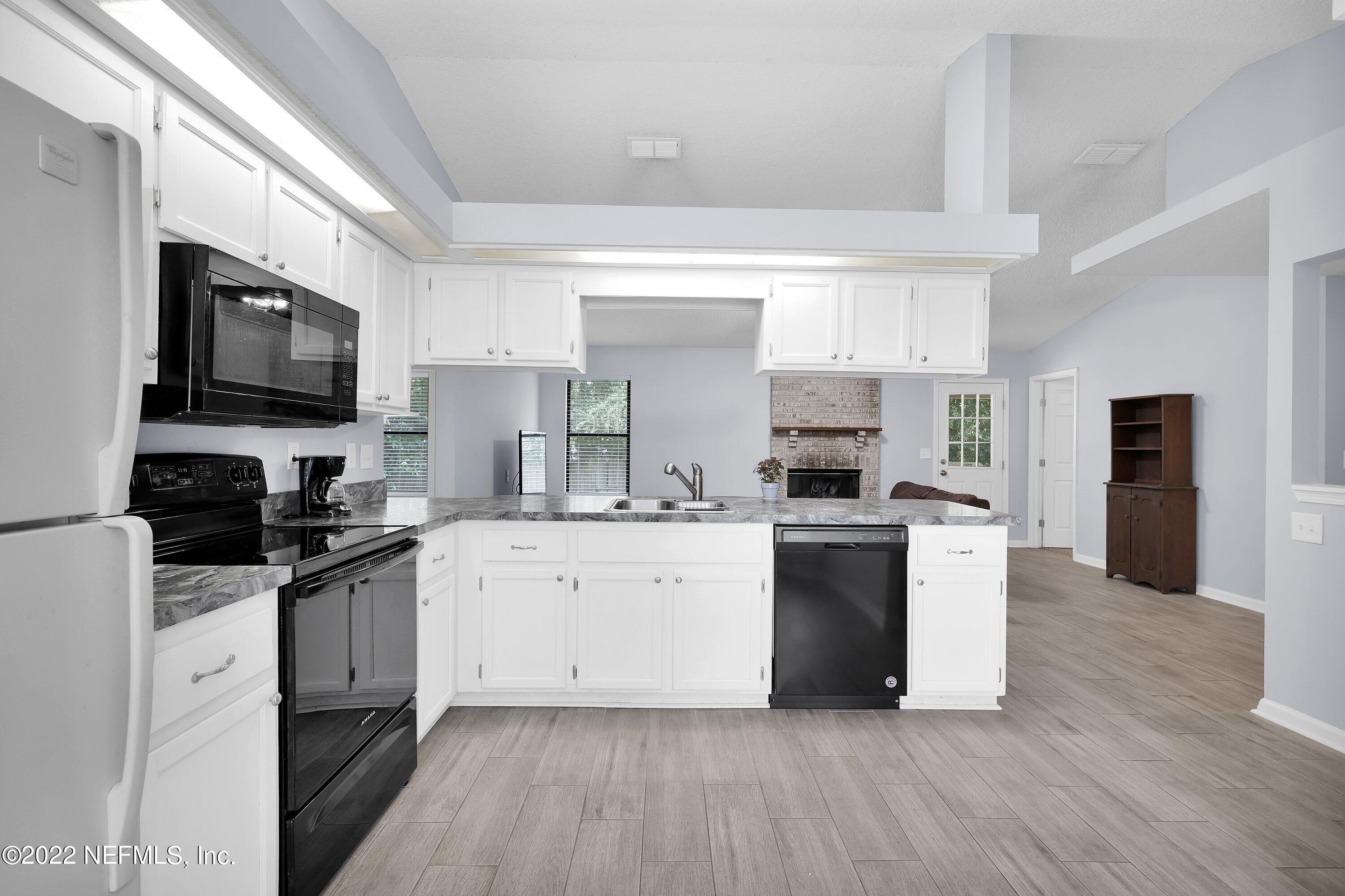 3248 Dowitcher Lane Orange Park, FL 32065 - Photo 6 of 26 a kitchen with a sink wooden floor and stainless steel appliances