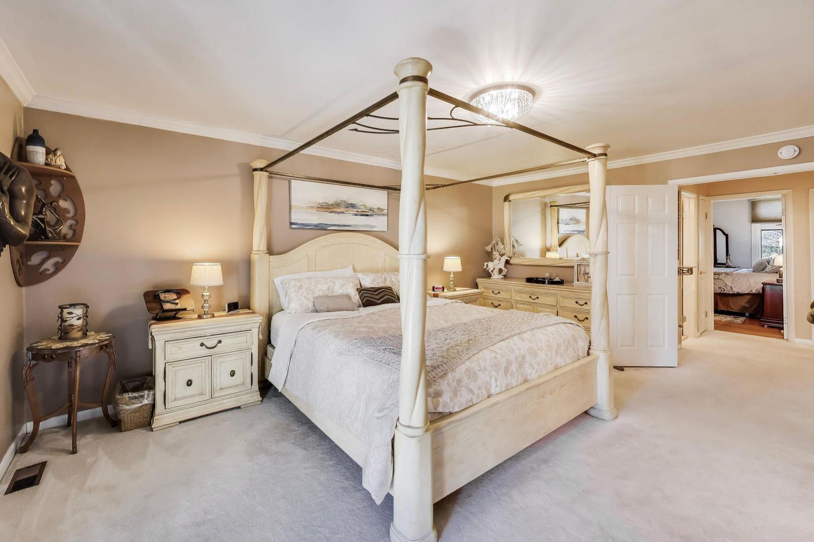 1 Maple Tree Court Elmhurst, IL 60126 - Photo 12 of 34 a bedroom with a large bed and a chandelier