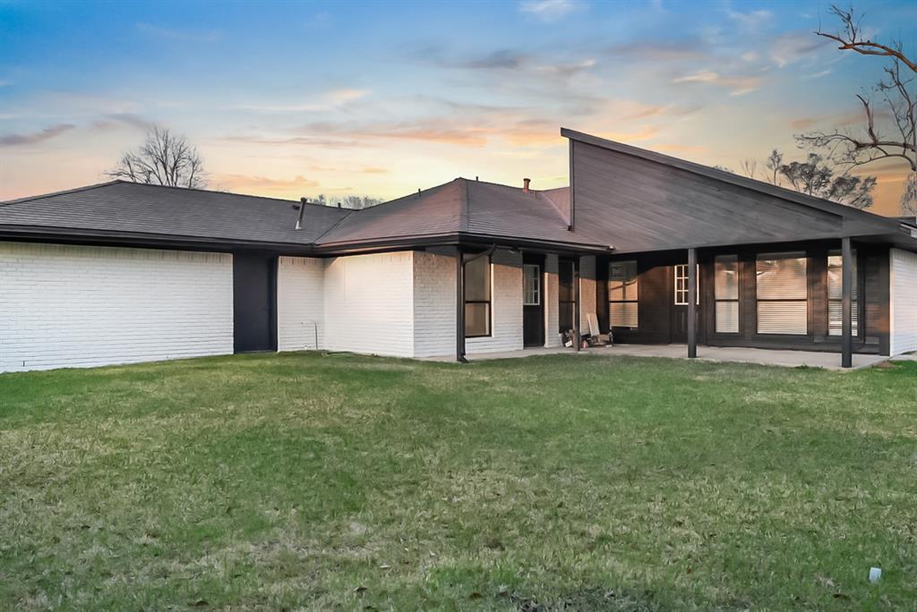 13103 Halwin Circle Dallas, TX 75243 - Photo 15 of 15 Rear view of property with brick siding, a patio area, and a lawn